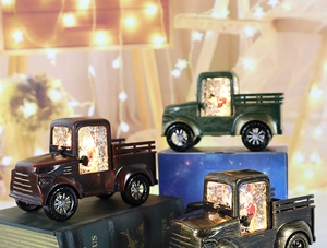 Close-up of vintage Christmas pickup truck lanterns with glitter snow and warm LED lights