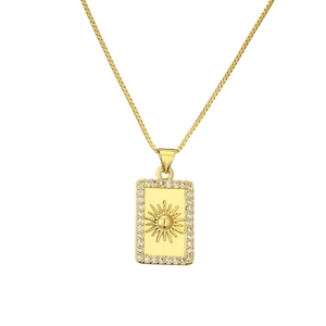 Close-up of a gold sun square pendant necklace with clear zircon stones on a fine chain