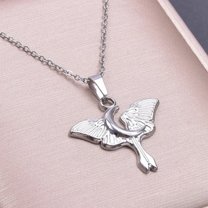 Close-up of silver moth and crescent moon pendant in a jewelry box for DIY necklaces