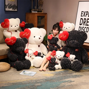 Detail of teddy bears in white and grey holding red heart balloons with golden text