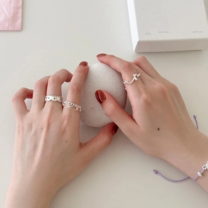 Détail de la bague coeur évidé en argent et bague noeud portée sur la main