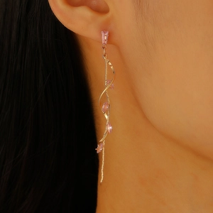 Detail of pink marquise zircon tassel earring with gold spiral twist on a model