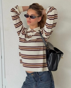 Close-up of retro striped polo shirt with collar paired with denim jeans and handbag