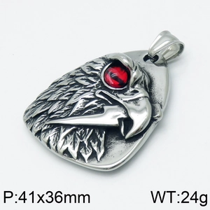 Detail view of silver eagle head pendant with red gemstone eyes and textured feathers