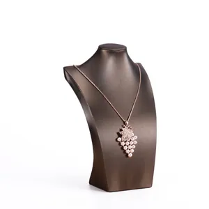 Grape shape necklace with white pearls and diamond leaf on brown mannequin stand