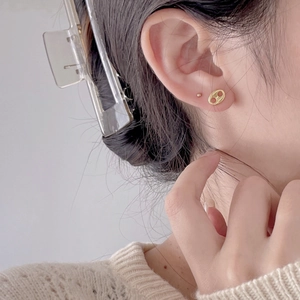 Close-up of gold coffee bean stud earrings worn by a model for a chic minimalist look