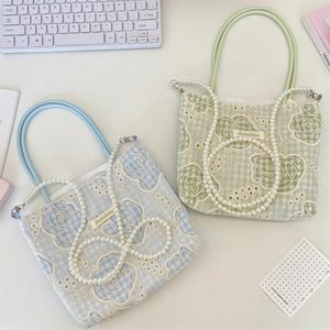 Détail de la broderie florale en dentelle et bandoulière perle sur sacs en toile