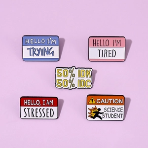 Macro detail of five colorful enamel pins with humorous text on a lilac background