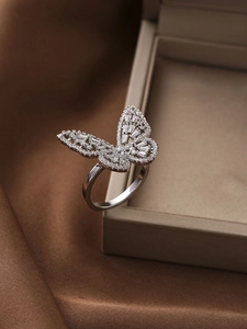 Detail of silver butterfly ring with sparkling stones on soft silk and jewelry box