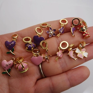 Golden enamel charms set with heart, clover, and crown shapes for DIY jewelry making
