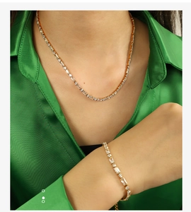 Detail of luxury gold tennis necklace and bracelet set with cubic zirconia on a model