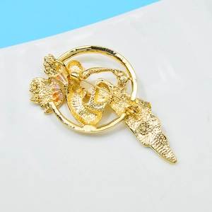 Detail shot showing the matte gold finish and sturdy back pin closure of the brooch