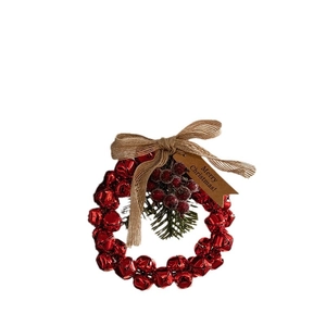 Christmas wreath with red bells, linen bow, and pine needles on a white background