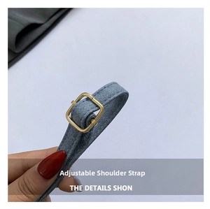 Detail view of adjustable denim shoulder strap with gold-tone square metal buckle