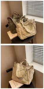 Detail view of quilted tote bag in beige and khaki showing stitching and side pockets