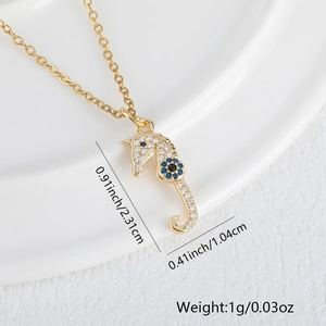 Detailed macro view of gold-plated seahorse pendant with sparkling white cubic zirconia