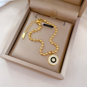 Titanium steel gold bead bracelet with Roman crystal ring pendant on jewelry box