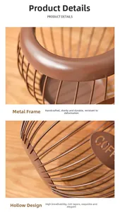 Detail of a brown wire coffee capsule basket with a metal COFFEE plaque on a wood table