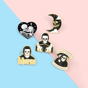Detail of five dark-themed enamel pins featuring skulls and skeletons with gold metal edges