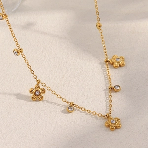 Detail of 18K gold plated flower necklace with cubic zirconia charms and link chain