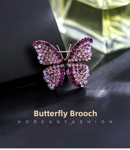 Close-up of sparkling purple rhinestone butterfly brooch with gradient wing details