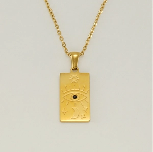 Macro detail of 18K gold stainless steel Tarot necklace with celestial sun and moon motifs