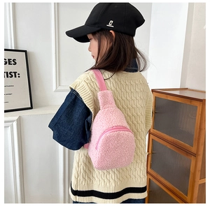 Rear view of a child wearing a pink plush fleece crossbody bag with an adjustable strap