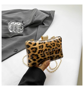 Detail of leopard print evening clutch featuring gold metal frame and crystal clasp