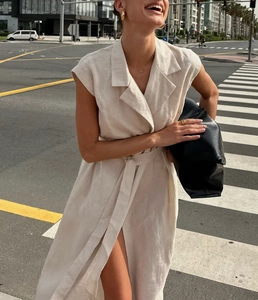 Detail of off-white sleeveless wrap dress with lapel collar and waist tie belt
