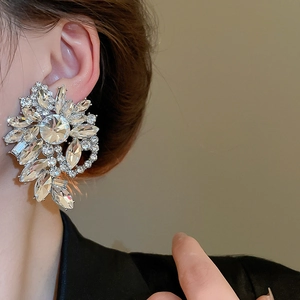 Detailed macro shot of a large flower-shaped earring with brilliant crystal embellishments