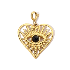 Macro detail of golden heart pendant with black evil eye stone on a polished spring clasp