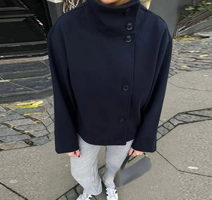 Détail du manteau court en laine bleu foncé avec col montant et boutons élégants