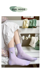 Detail view of tulip floral embroidery on soft macaron colored cotton crew socks