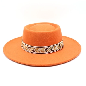Close-up of bright orange wool felt hat with decorative geometric patterned band