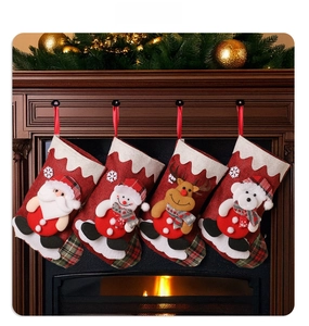 Close-up of four burlap Christmas stockings with 3D Santa and reindeer on a fireplace