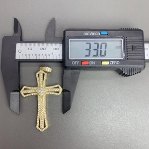 Macro view of gold cross pendant showing detailed 33mm height measurement with digital caliper