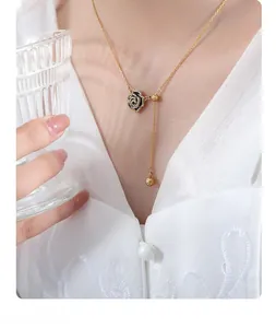 Detail of gold rose pendant with black enamel inlay and crystals on an elegant chain