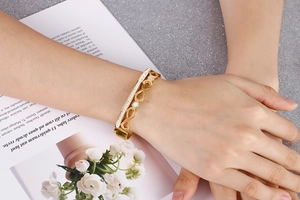 Detailed view of a gold infinity bracelet featuring double-row sparkling white stones