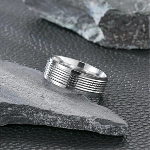 Herrenring aus Titanstahl im Industriedesign auf rauem Stein und Lederhintergrund präsentiert