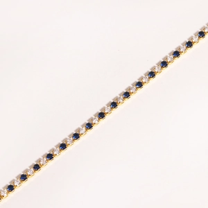 Minimalist gold tennis bracelet with alternating blue and clear round zircon gemstones