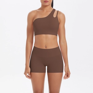 Detail of dark brown one-shoulder sports bra with cutout and matching high waist shorts