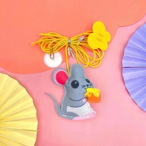 Detail of hanging felt mouse cat toy with yellow cheese and elastic string on colorful background