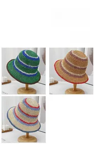 Detailed macro view of striped handmade straw sun hats with wide brims in three colors