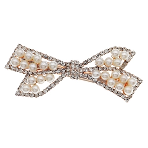 Luxury rhinestone bow hair clip with pearls and golden metallic base on white background