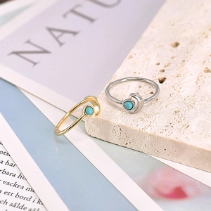 Detail of crescent moon rings in gold and silver finish with turquoise stone inlays