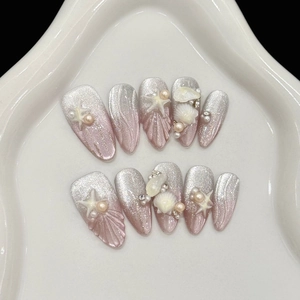 Detailed view of handmade ocean themed press-on nails with 3D starfish and shell textures
