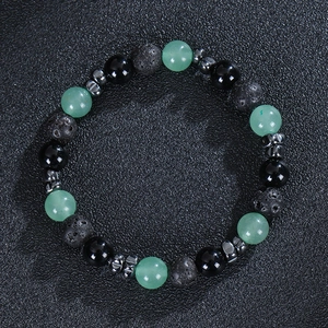 Close-up of mixed 8mm beads showing green crystal and black volcanic stone texture