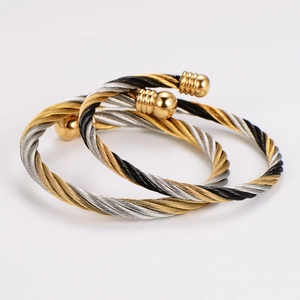 Detailed macro shot of twisted stainless steel cable bracelets with golden sphere ends
