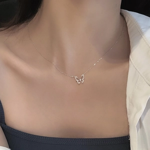 Collana a farfalla in argento con pavé di zirconi indossata su un collo per un look raffinato