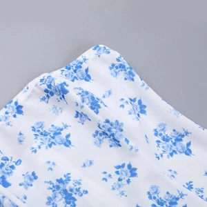 Dettaglio ravvicinato della stampa floreale blu su tessuto bianco con cuciture rifinite